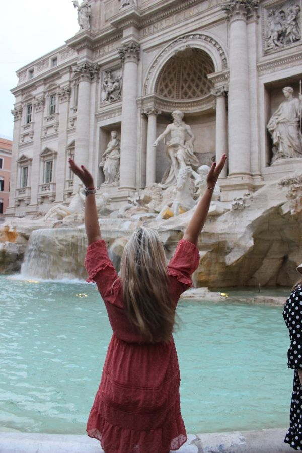 Dívka před kašnou vody v historické části města v Itálii